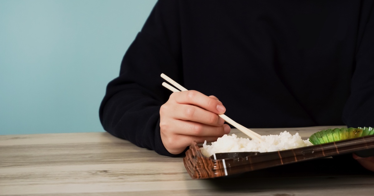 コンビニ弁当を食べる手元